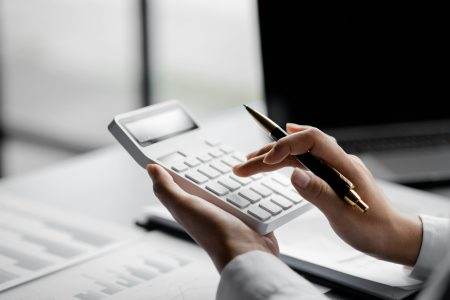 Businessman is using a calculator to calculate.