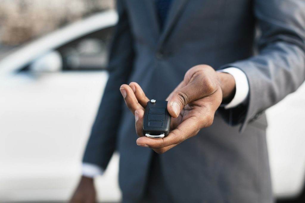 Car sale concept. Man hand giving car key