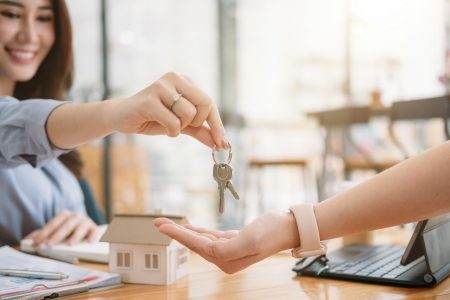 Client taking keys from female real estate agent during meeting after signing rental lease contract