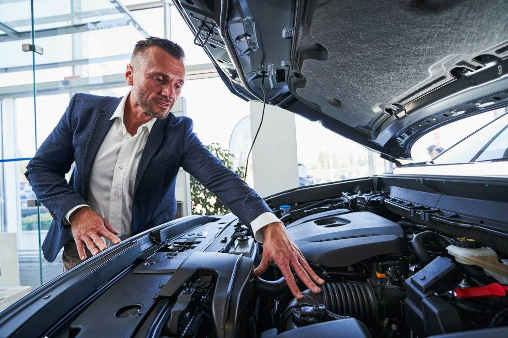 Expert in selling cars paying attention to under hood parts