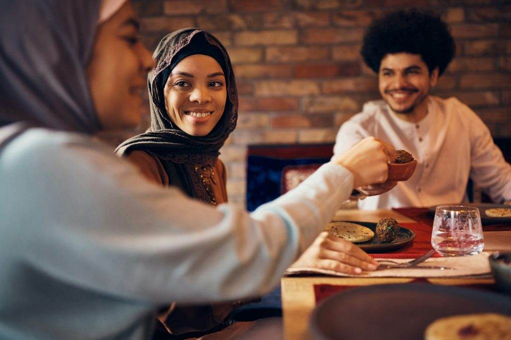 Happy Middle Eastern family enjoying in Ramadan Iftar meal at home.