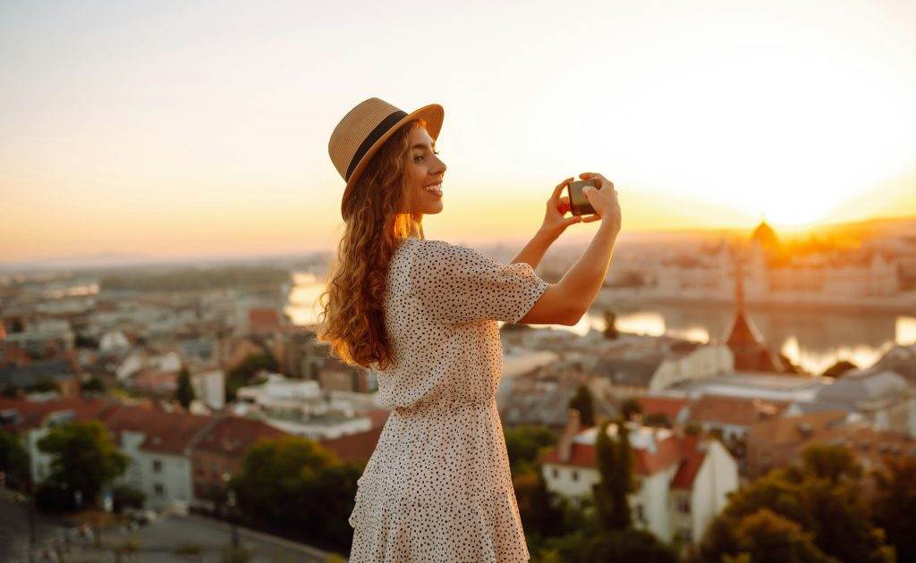 Travel in Europe. Young woman enjoys sunrise. The concept of travel, tourism, vacation and freedom.