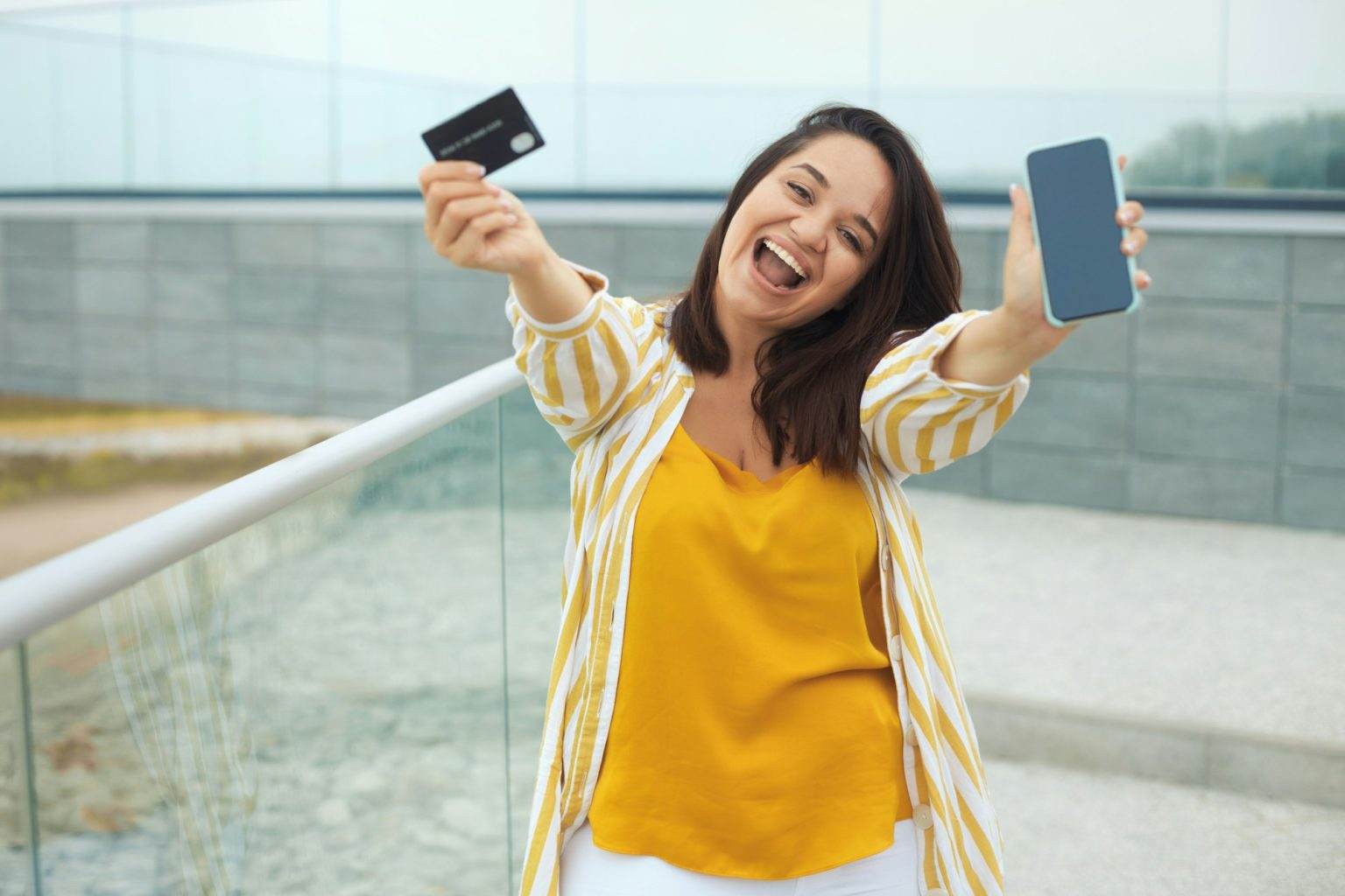Happy woman made a payment with a bank card online through an application in a mobile phone
