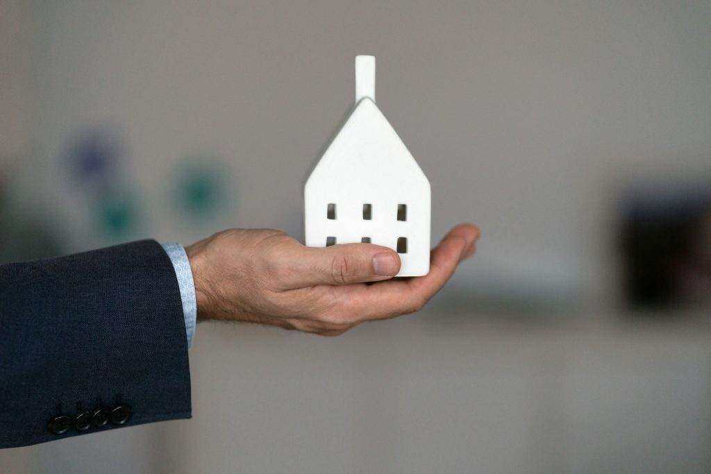 Holding the model house, real estate insurance and banking concept