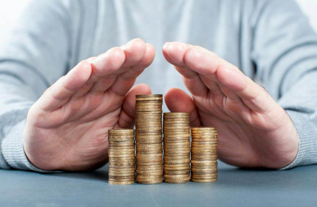 Money saving concept. Many coins and men's hands. Insurance, bank deposit