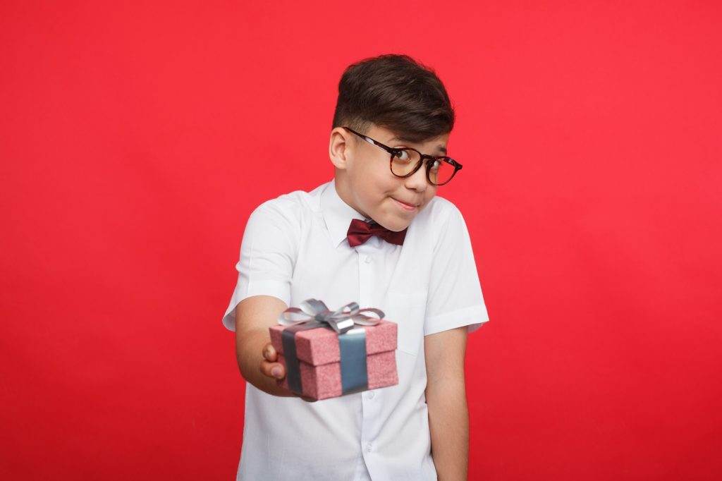 Shy boy offering giftbox