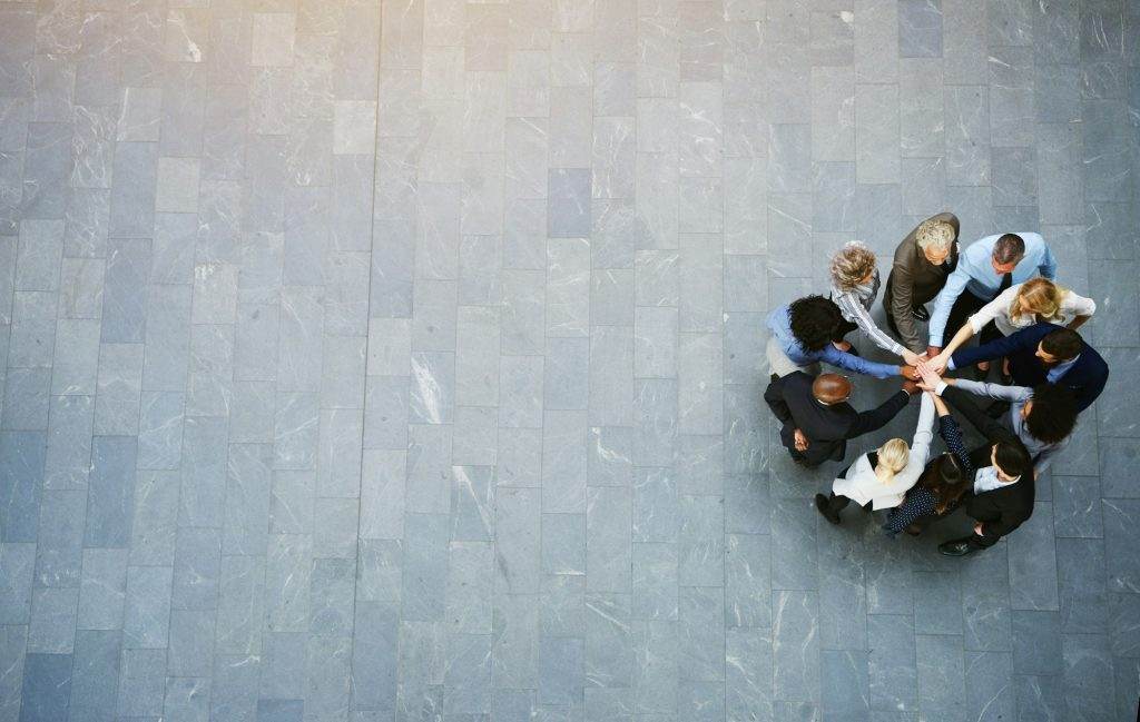 United colleagues standing in a huddle with their hands together