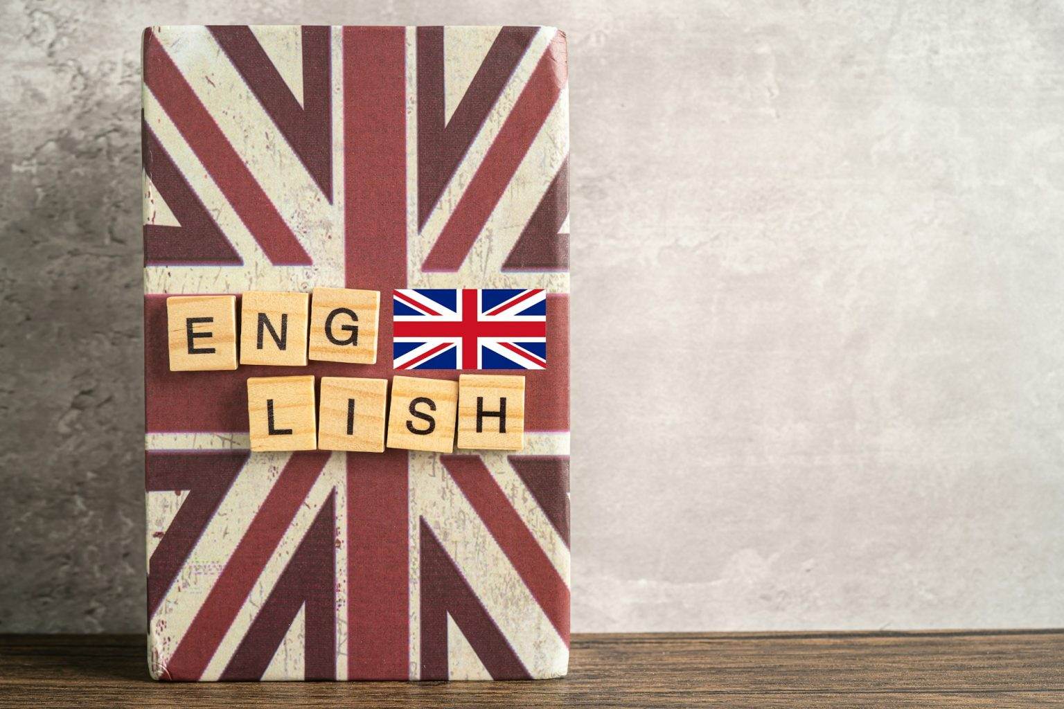 Word English on book with United Kingdom flag, learning English language courses concept.