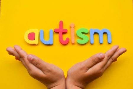 Child's hands open with word autism.