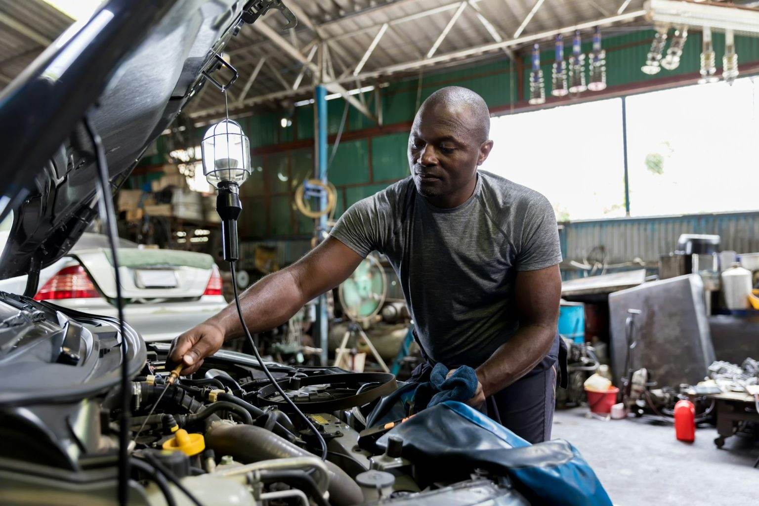 Car mechanic checking oil quality the engine motor car Transmission and Maintenance Gear.