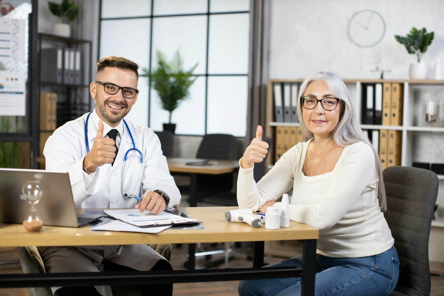 Doctor and patient showing thumb up and smiling on camera