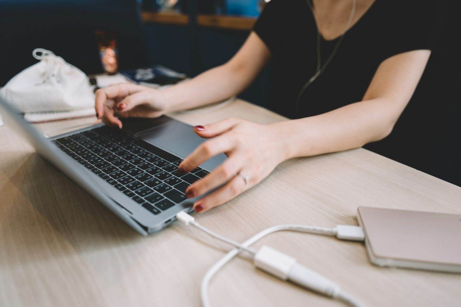 Woman working in cafe using laptop and external hard disk