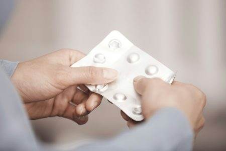 Hands of woman holding pack of medicament