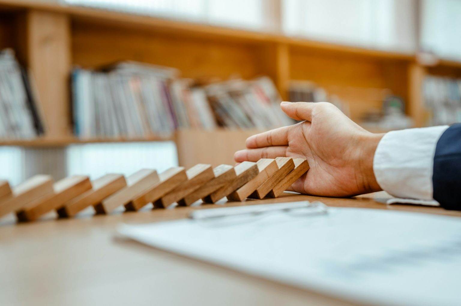 Entreprise en Faillite : Comprendre et Agir Face à Cette Crise Strategy and successful intervention concept for business, businessman hand Stopping Falling wooden