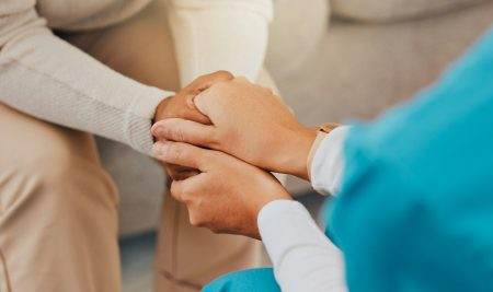 Holding hands, support and empathy with nurse and patient for trust, help and counseling in a nursi