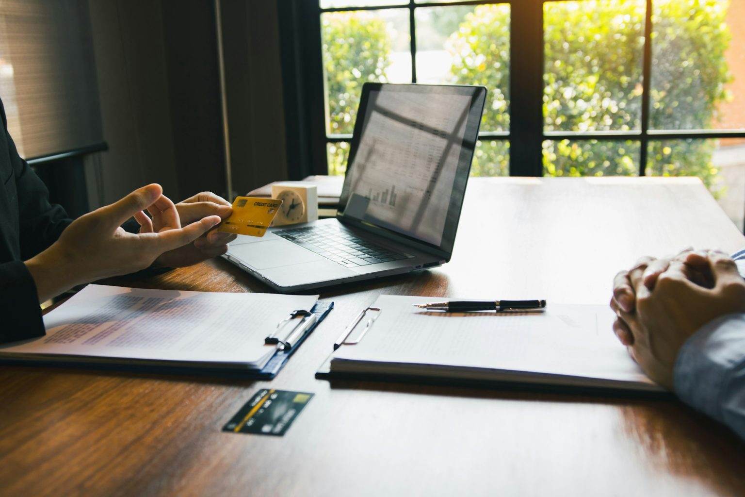 The bank clerk is talking to a customer who applied for a credit card service at the office.