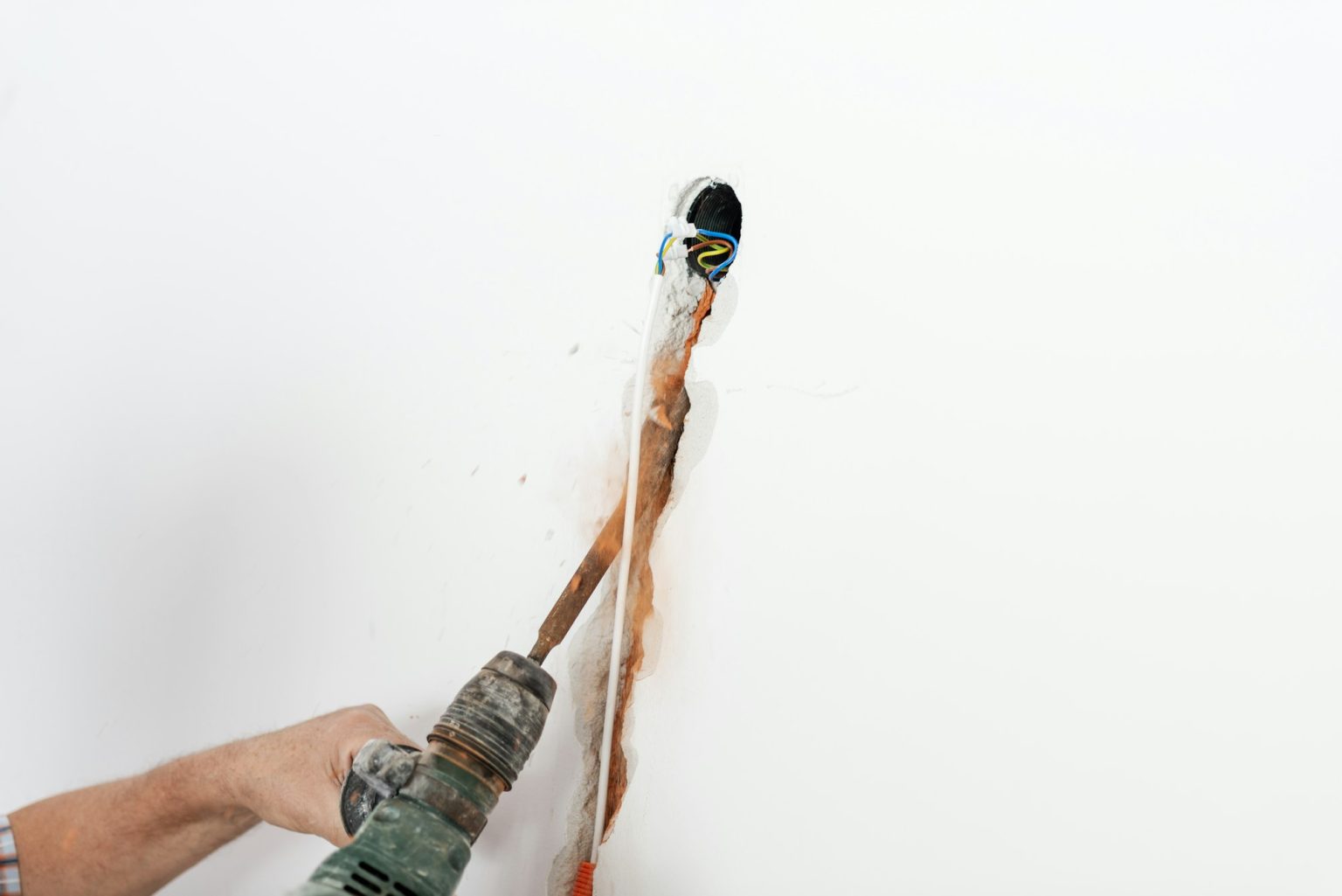 A machine drilling hole in the wall for electrical wires
