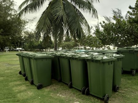 A row of green dustbin with sun flare.Pollution concept.