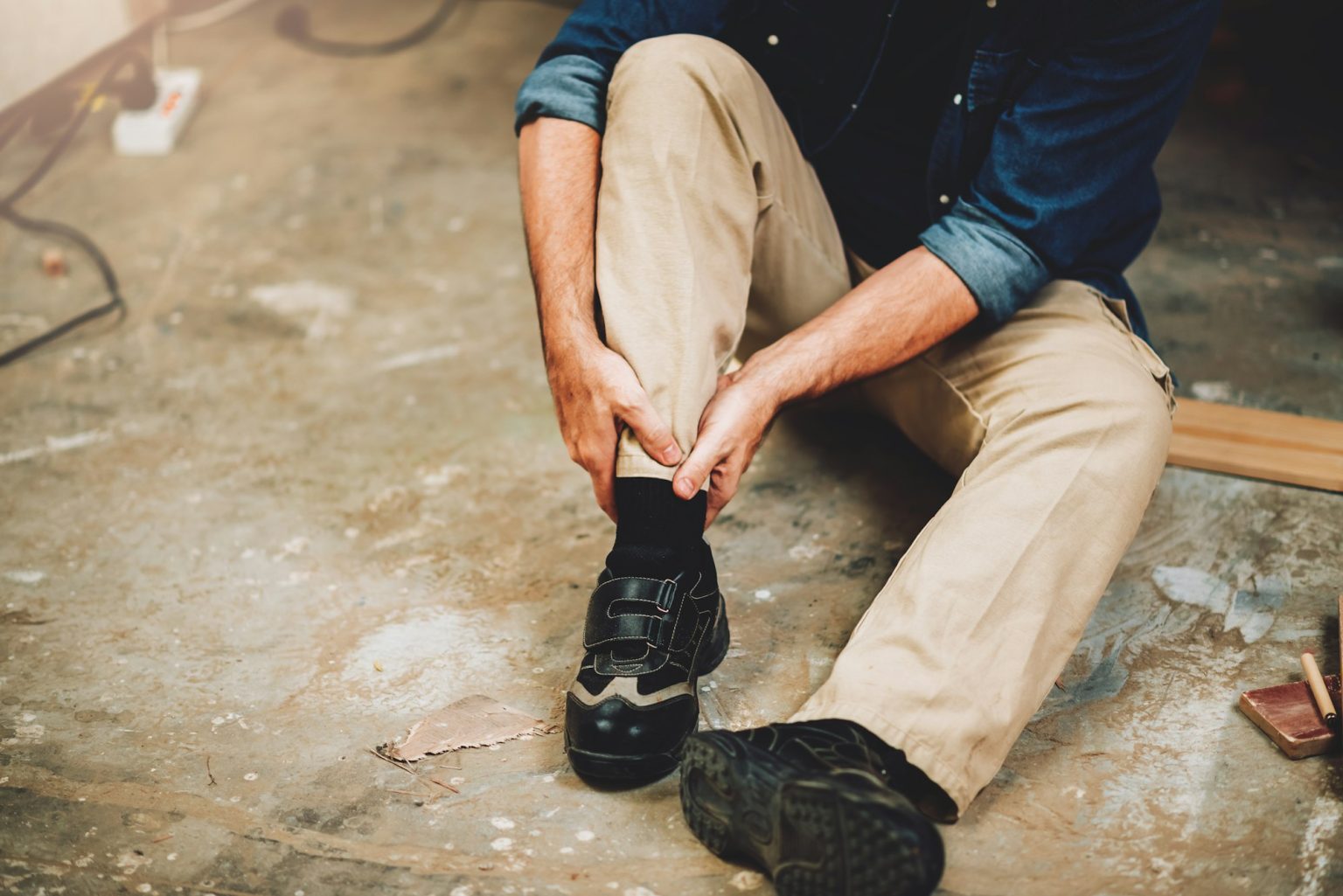 Senior caucasian man has an accident while working in wood workshop