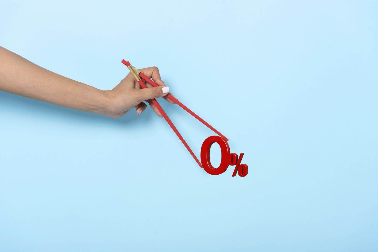 Comment obtenir et calculer son Prêt à Taux Zéro ? Woman hand holding chopsticks showing 0% number or zero percent isolated on blue banner background.
