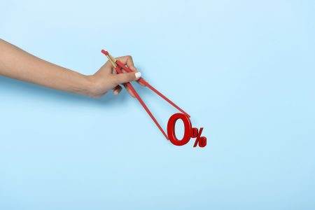 Woman hand holding chopsticks showing 0% number or zero percent isolated on blue banner background.