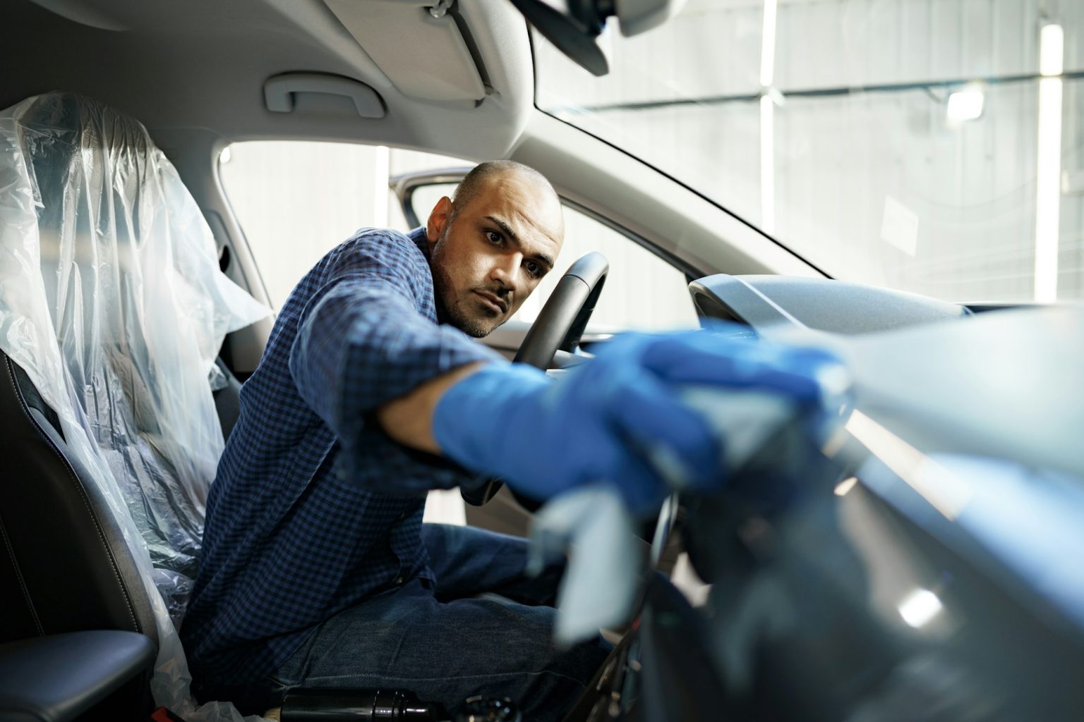 A man cleaning car interior, car detailing in Carwash service