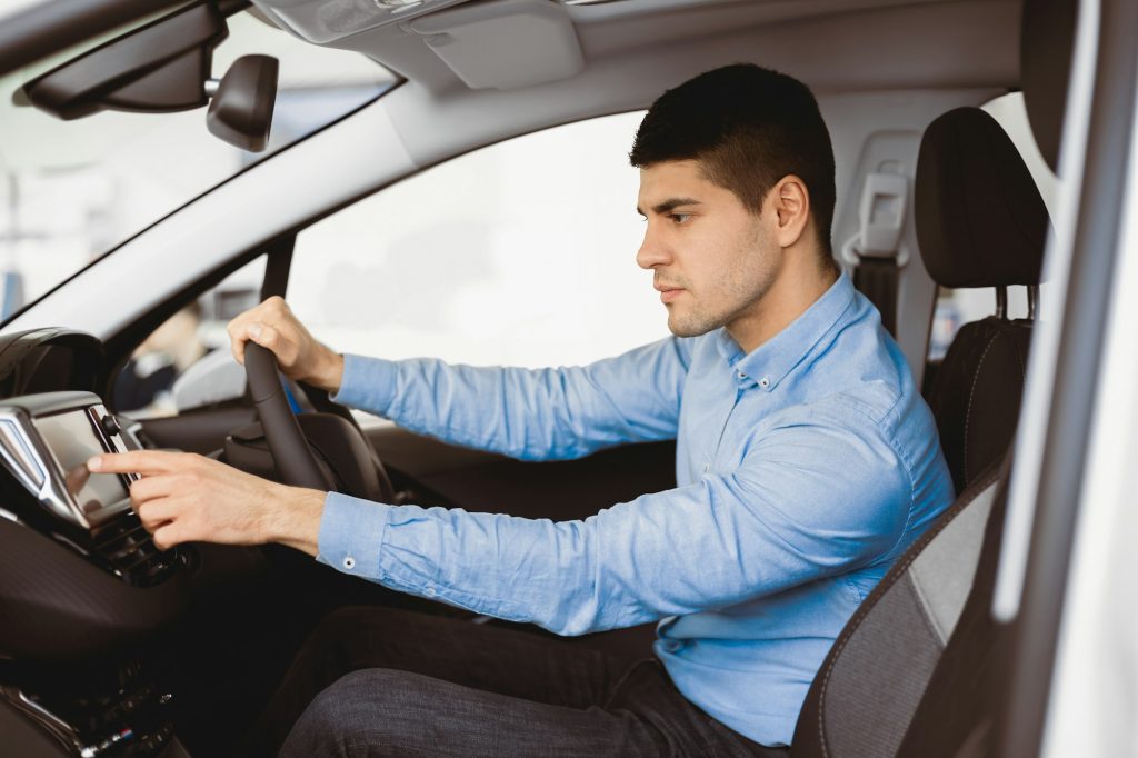 Businessman Sitting In New Auto Checking Navigation System