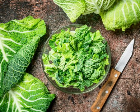 Cabbage salad in a bowl with a knife.
