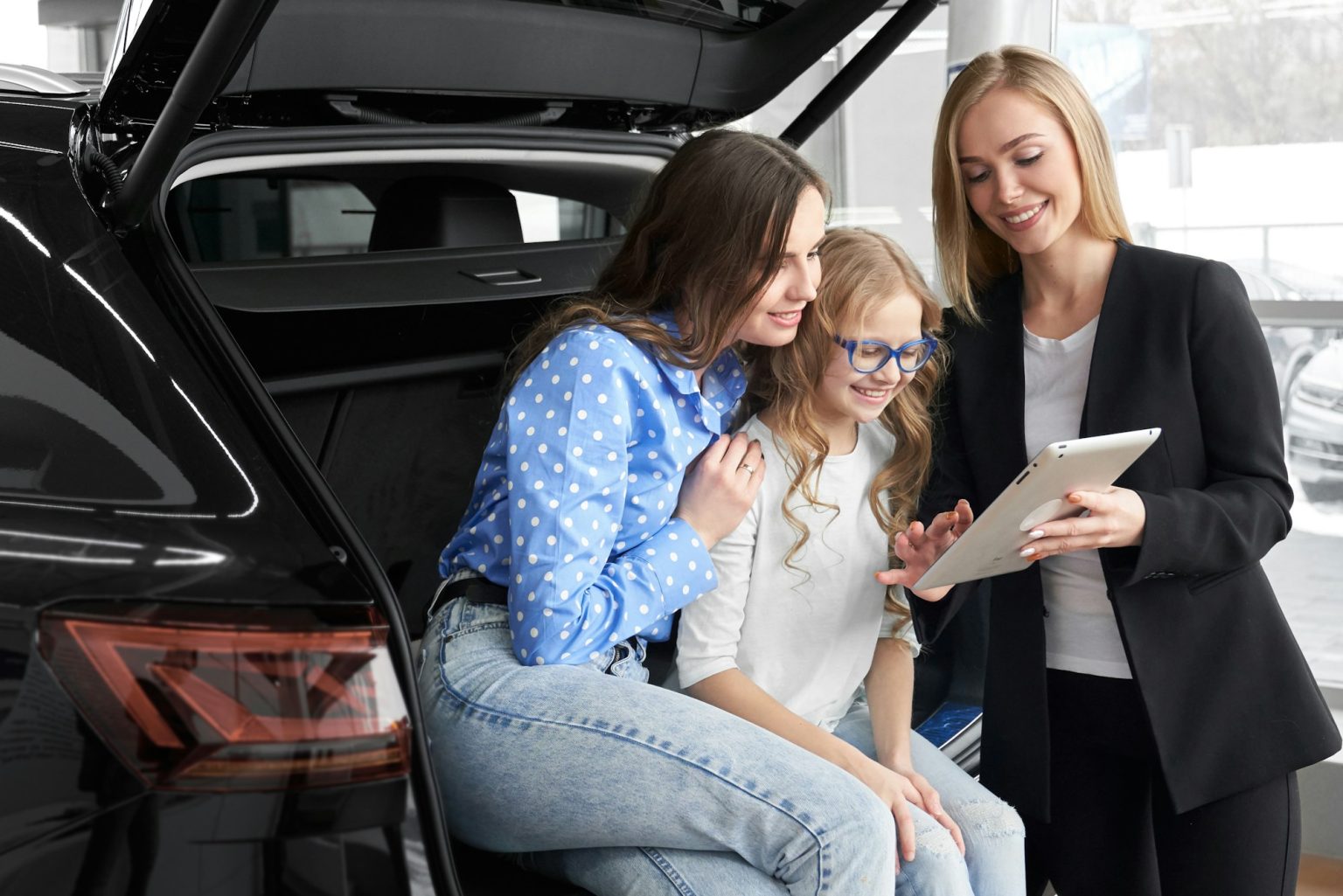 Car dealer consulting and helping family in choosing auto