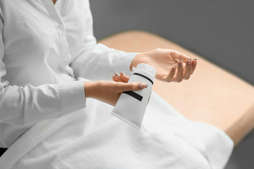 cold season hands skin protection. closeup woman applying protective cream on hands.