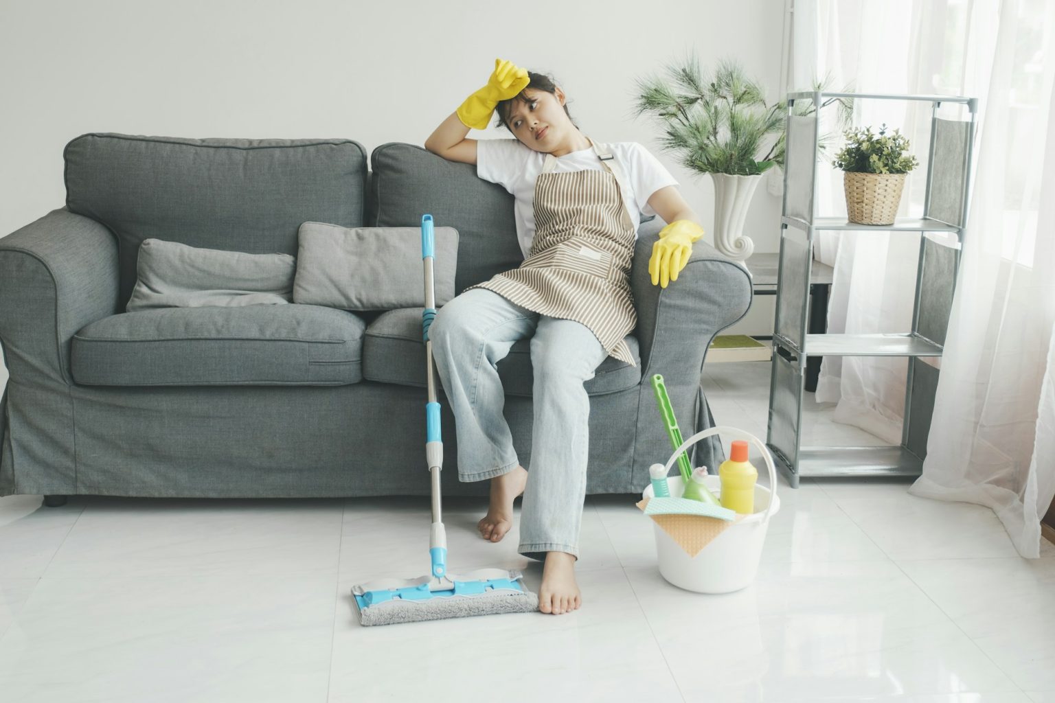 Exhausted woman resting after cleaning home.