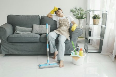 Exhausted woman resting after cleaning home.