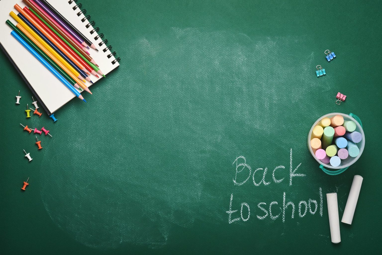 School supplies and black table lamp on green board. Concept back to school. Mock up for design. Cop