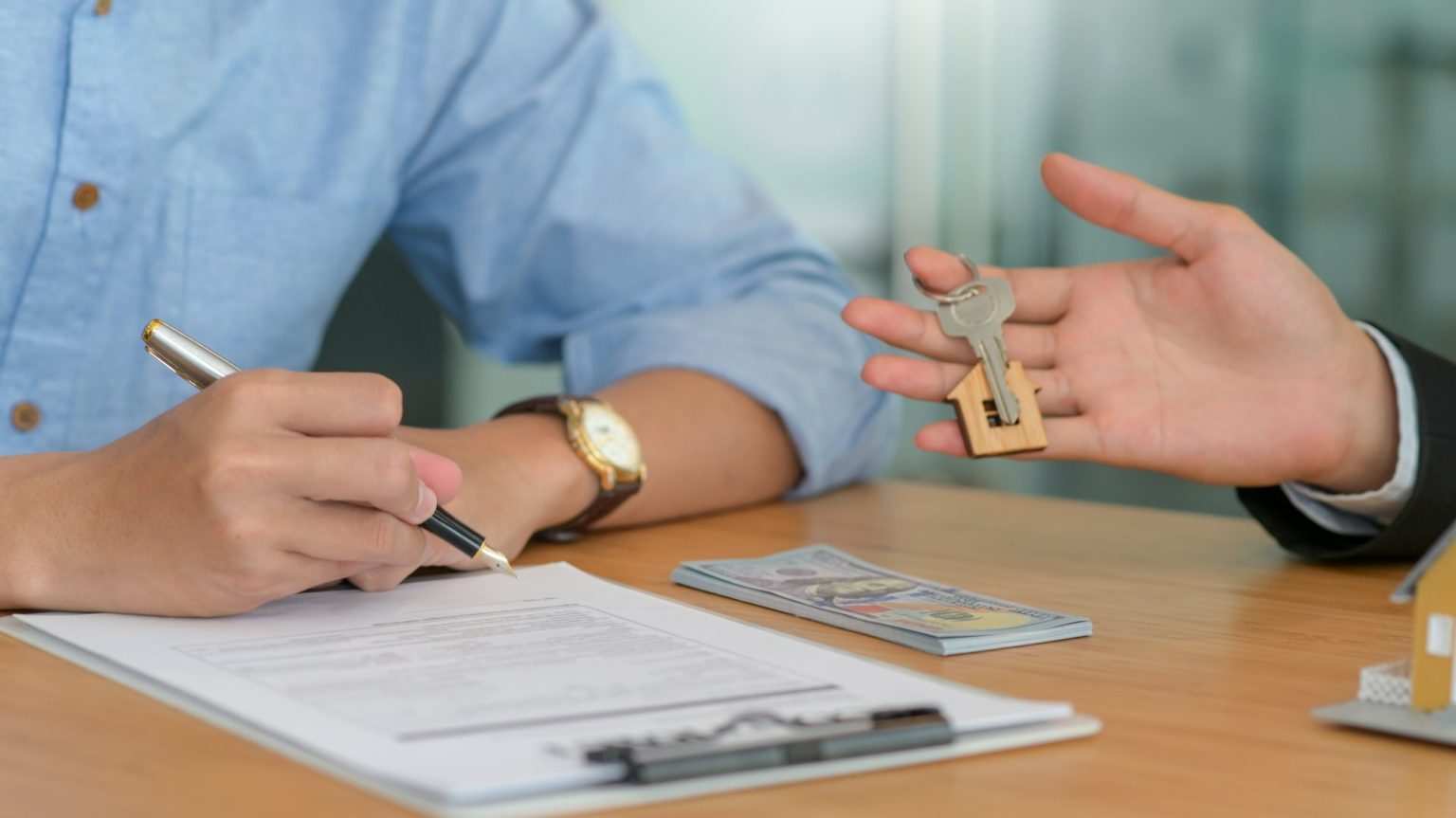 Signing a contract and delivering the house keys for buying and selling houses.
