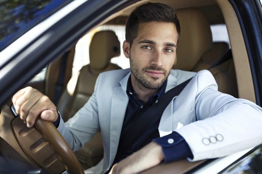 Successful young businessman driving in his car