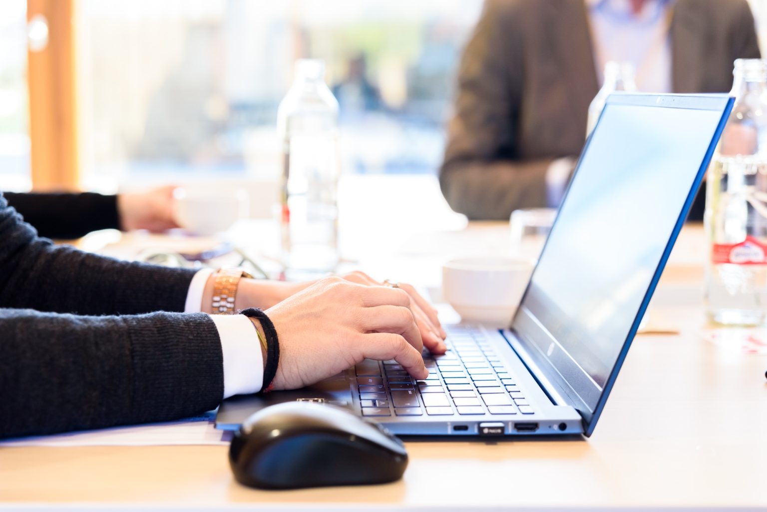 An enterprising employee types important information about her company on her laptop keyboard.