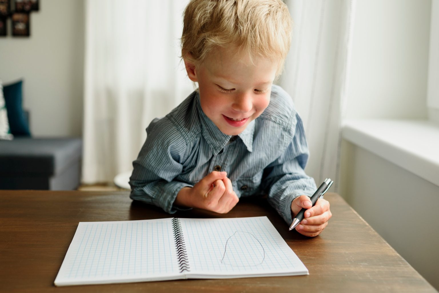 Child writing by left hand in notepad