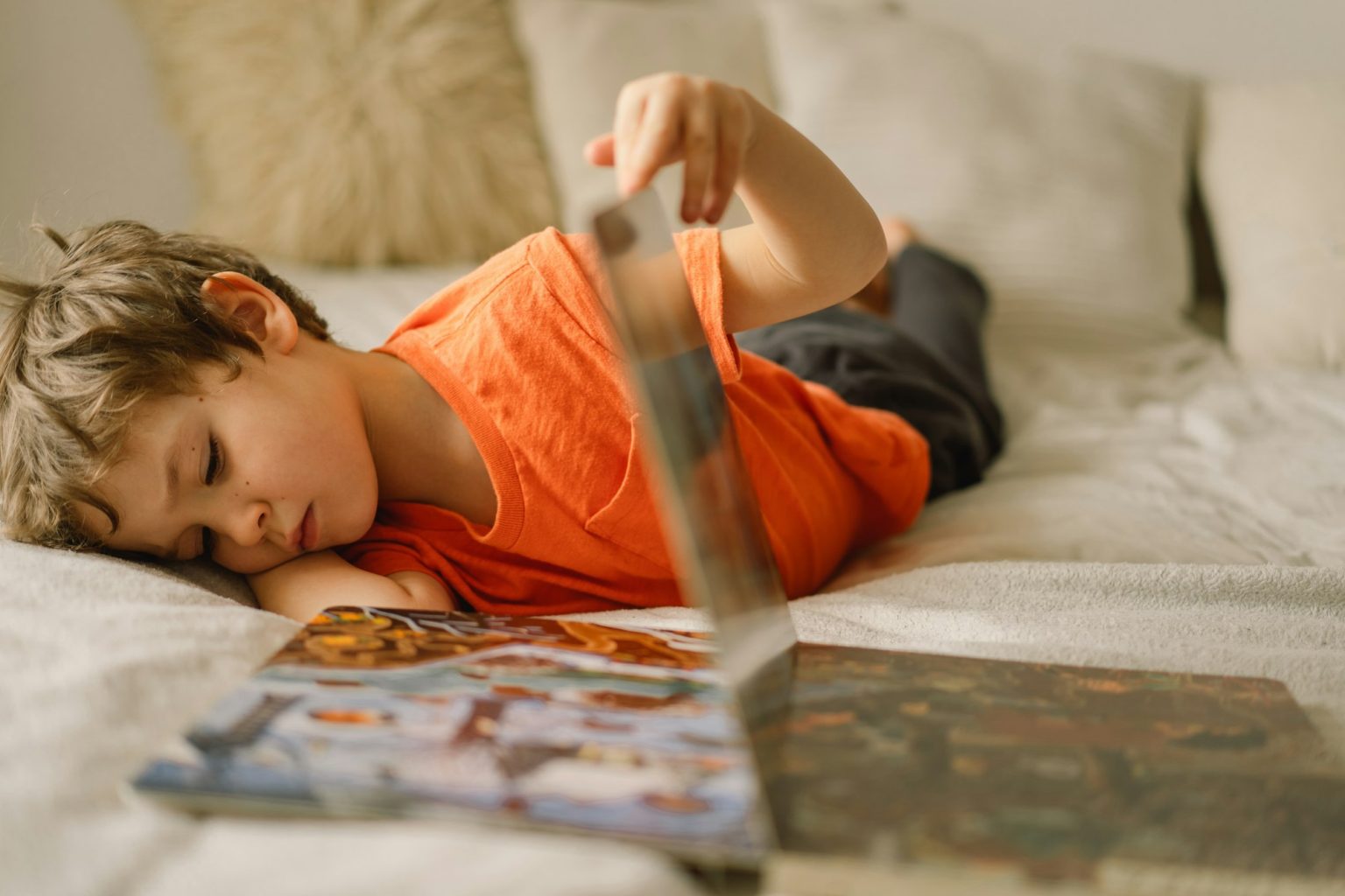 Kids read books. Little boy reading and plays with a book at home. Children home schooling.