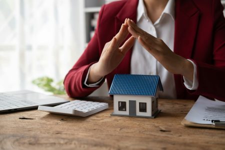 Property insurance and security concept. Protecting gesture of man and symbol of house.