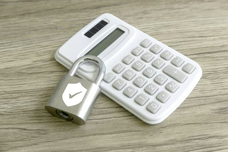 Securing Your Finances: The Symbolism of a Padlock with Shield and Checkmark on a Calculator