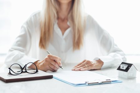 Business property, real estate and investment concept with investor and model house on white desk.