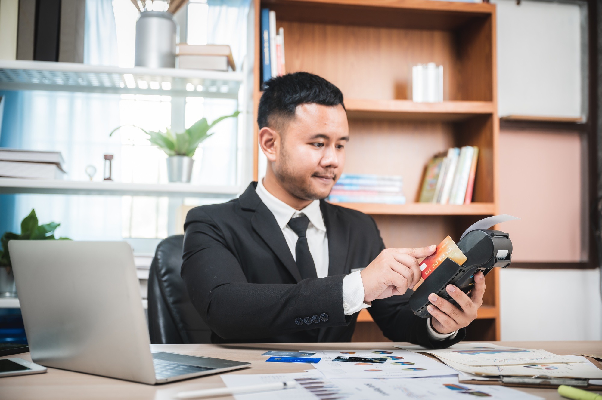 Businessman paying by credit card with a credit card reader machine
