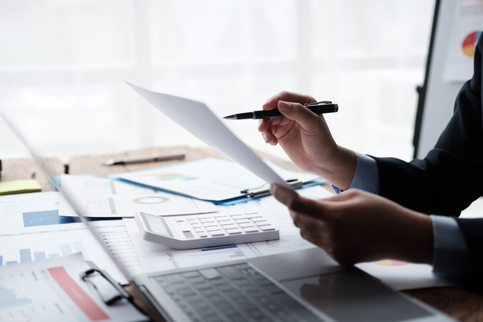 Businessman working with business report papers on office desk, financial chart analysis with calcul