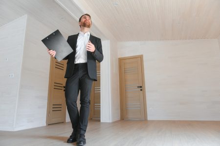 Estate Agent Looking Around Vacant Property For Valuation