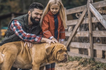 Farmer and his daughter caressing their dog