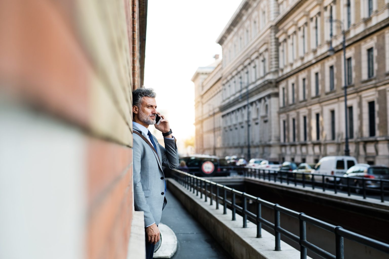 Mature businessman with smartphone in a city.