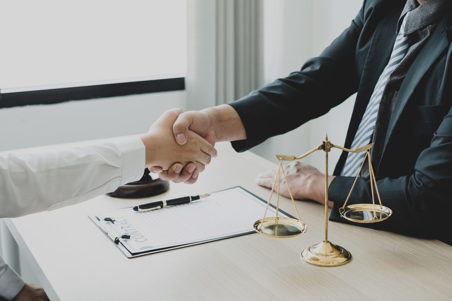 shake hand Professional man lawyers work at a law office There are scales