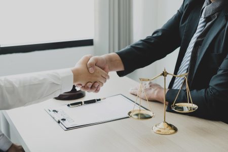 shake hand Professional man lawyers work at a law office There are scales