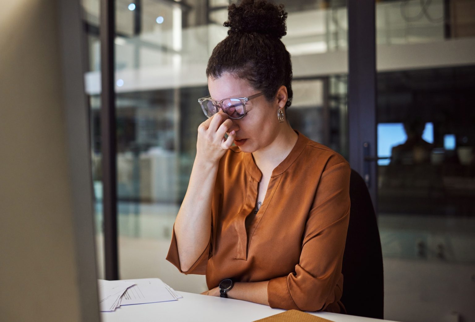 Stress, burnout and woman with a headache tired from working overtime at her office desk due to pap
