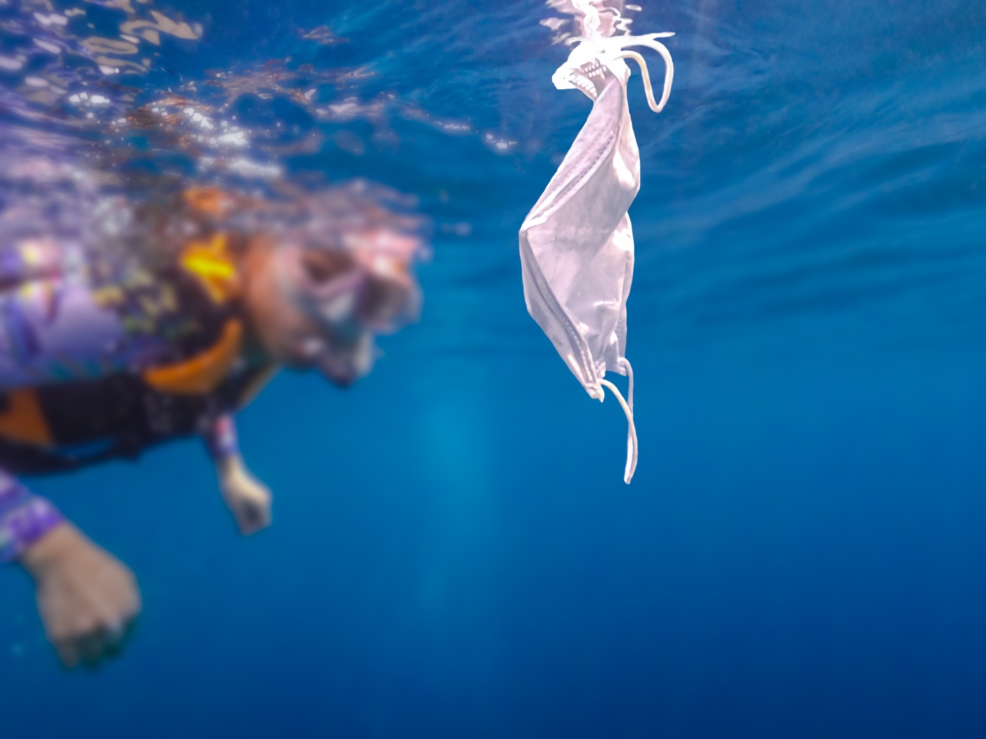 Volunteer woman scuba divers are exploring underwater and cleaning up the ocean.